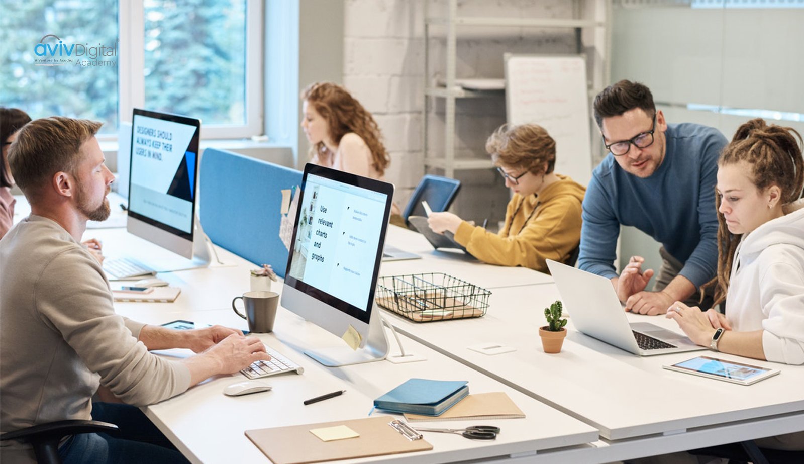 A digital marketing team collaborating in a modern office workspace with multiple computers and devices 